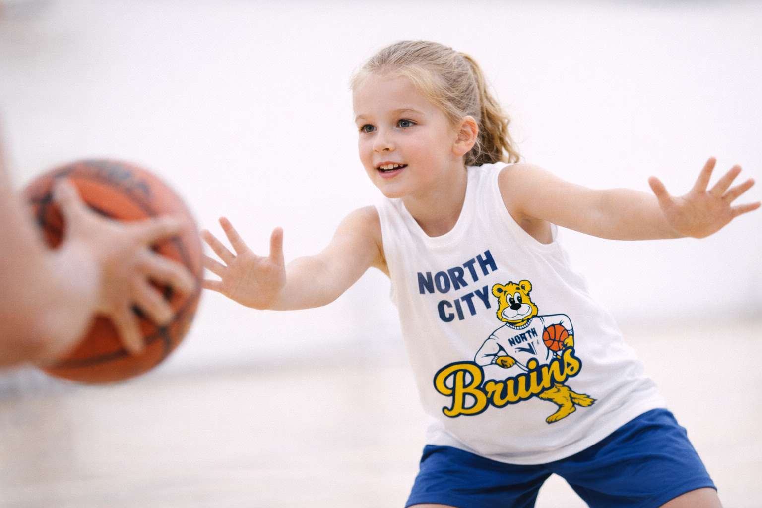 Boy dribbling basketball in North City Bruins jersey