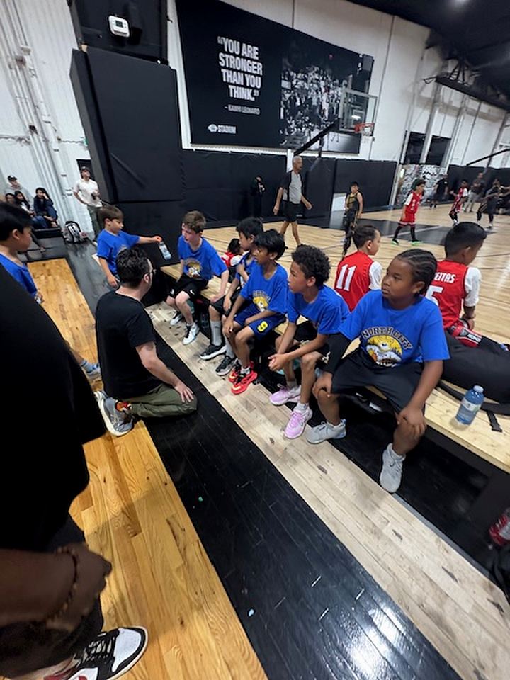 North City Bruins players listening to coaches on the bench during a game